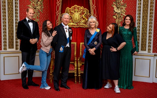 Tourists posing with wax figures of British royalty at Madame Tussauds, London.