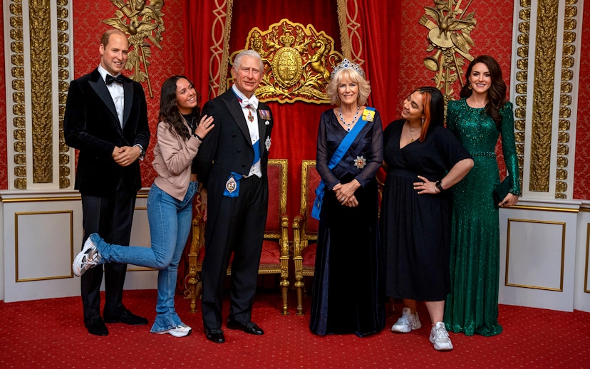 Tourists posing with wax figures of British royalty at Madame Tussauds, London.