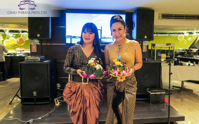 Guests holding krathongs on Chao Phraya Princess Loy Krathong festival dinner cruise.