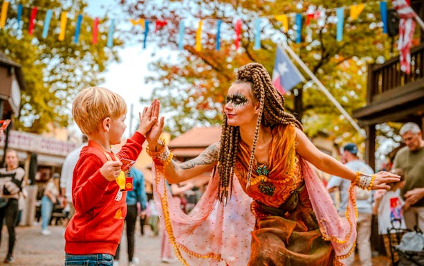 Child high-fiving performer at Halloween event in Bobbejaanland.