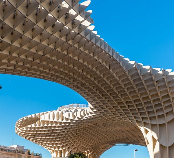 Setas de Sevilla wooden structure in Seville, Spain, with people walking below.