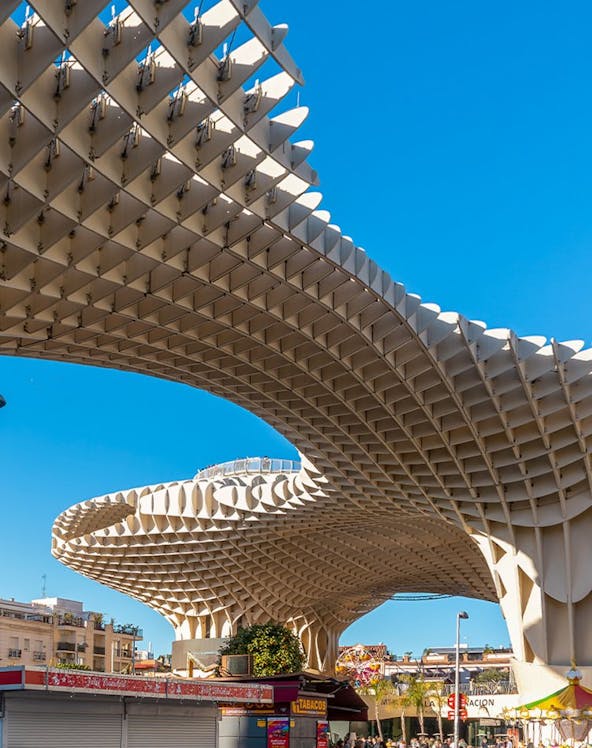 Setas de Sevilla wooden structure in Seville, Spain, with people walking below.