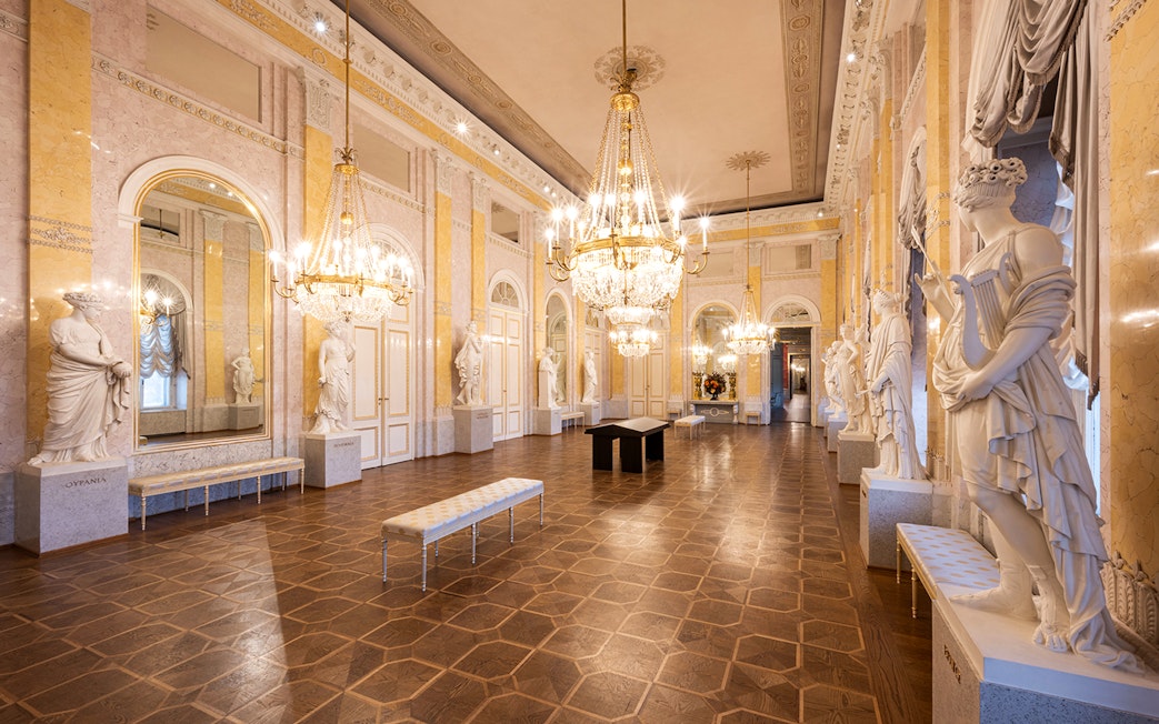 State rooms with chandeliers and statues inside Albertina Museum, Vienna.
