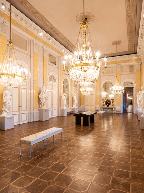 State rooms with chandeliers and statues inside Albertina Museum, Vienna.