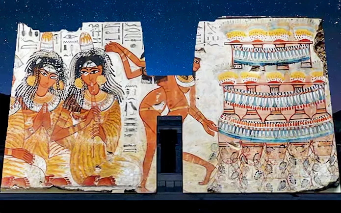 Edfu Temple wall illuminated with ancient Egyptian art during sound and light show.