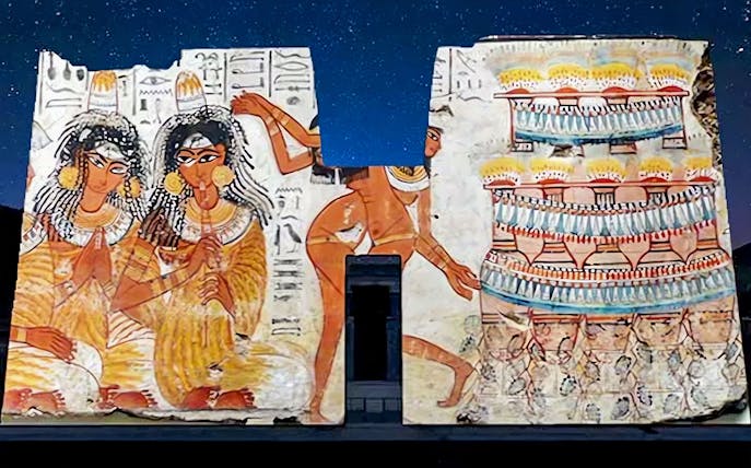 Edfu Temple wall illuminated with ancient Egyptian art during sound and light show.
