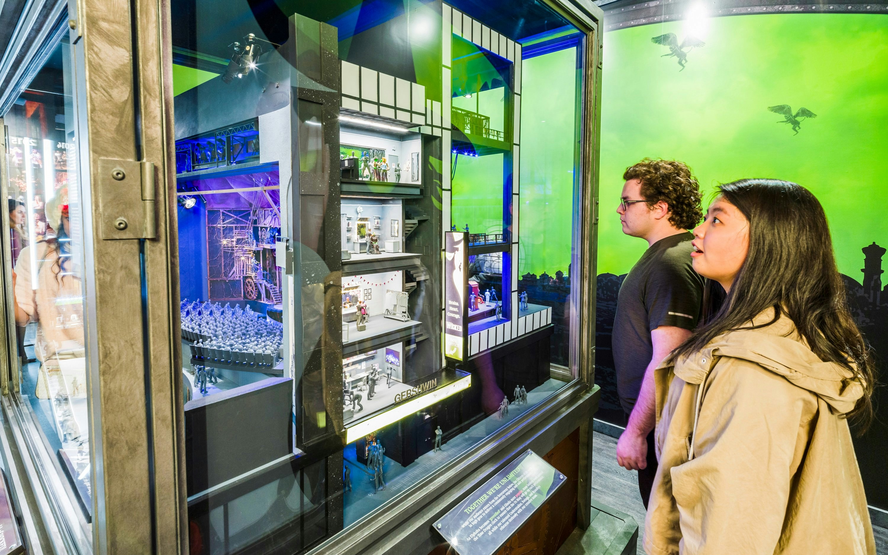 Visitors observing a Broadway stage model at the Museum of Broadway.