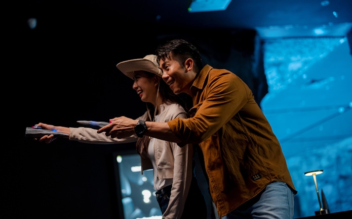 Couple using wearable devices at Enchanted Forest immersive exhibit.