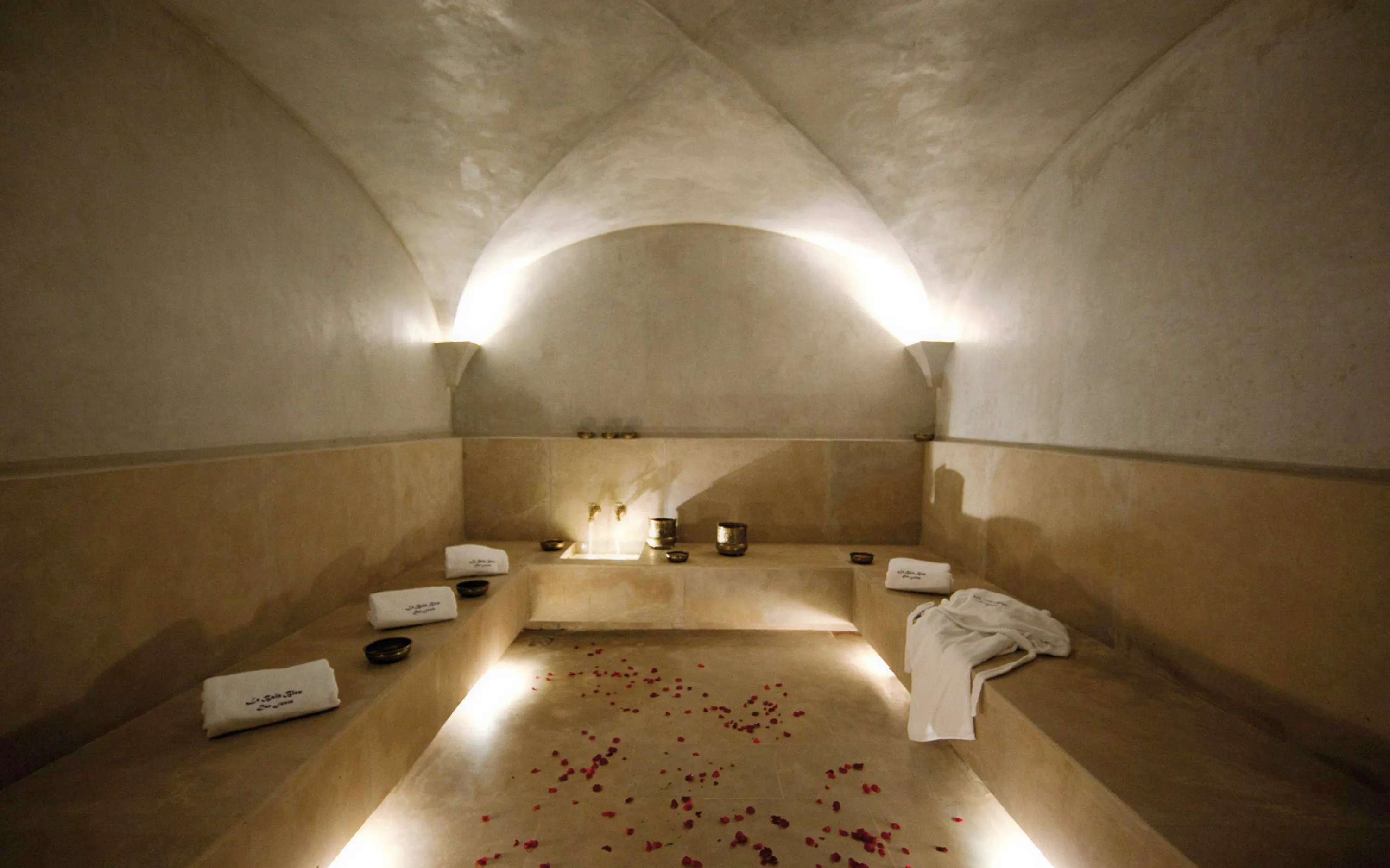 Le Bain Bleu Hammam interior with towels and rose petals, Marrakesh.