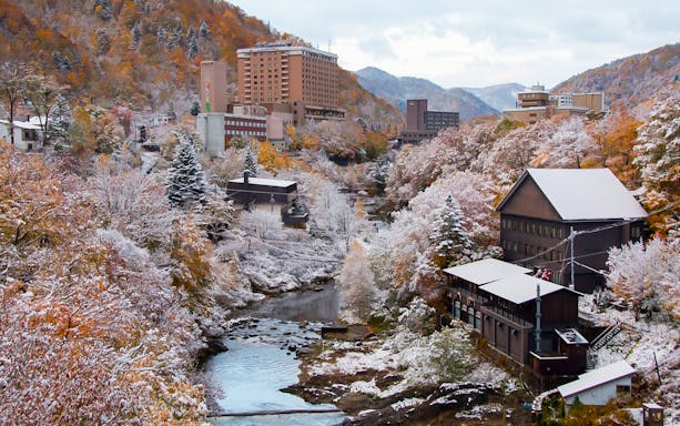 Jozankei Mori No Uta Onsen surrounded by snowy autumn foliage and mountains.