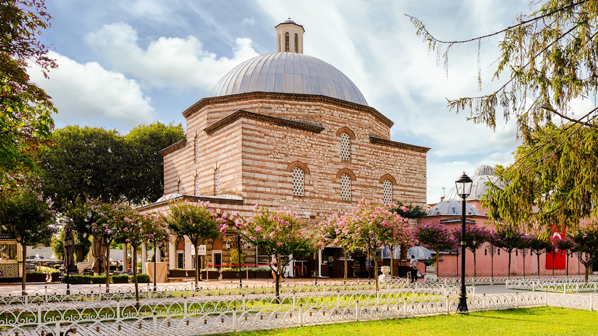 Traditional Turkish Hammam exterior with domed roof and garden in Istanbul.