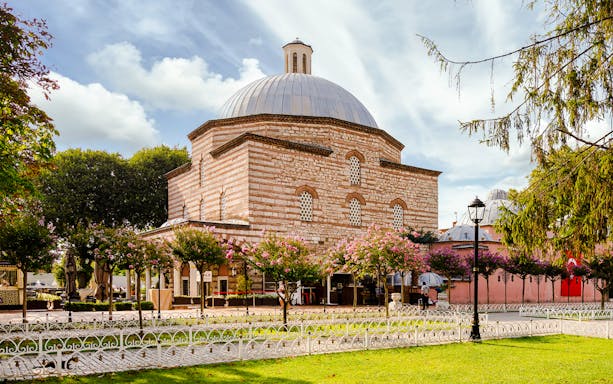 Traditional Turkish Hammam exterior with domed roof and garden in Istanbul.