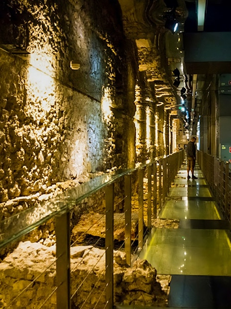 Walkway through ancient stone walls at Rynek Underground Museum, Krakow.
