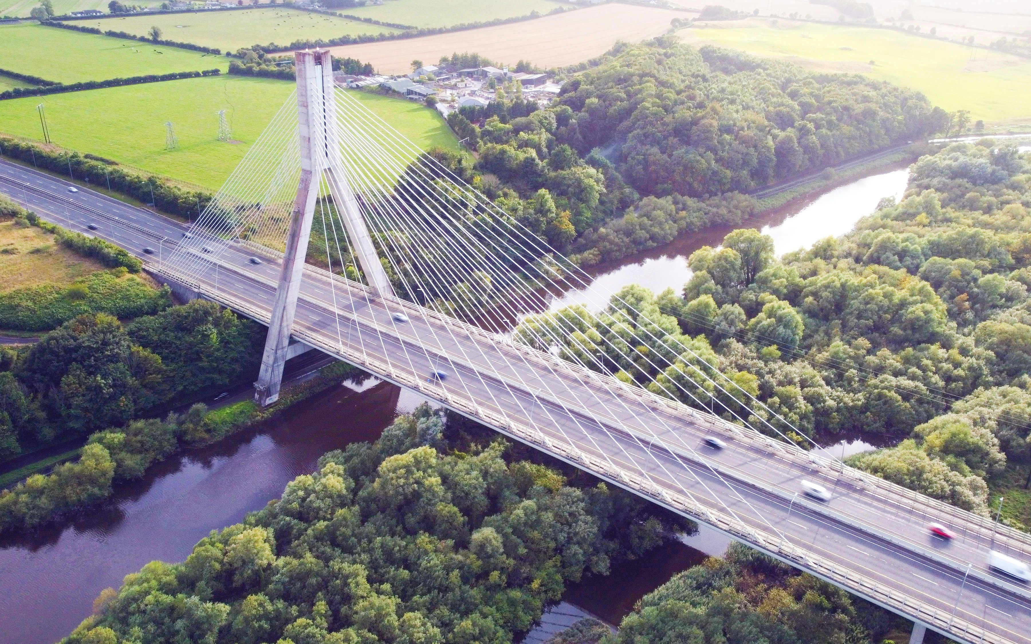 Cable-stayed bridge over the River Boyne in Boyne Valley, surrounded by lush greenery.