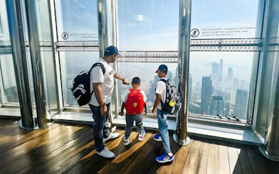 Family enjoying the view from The View At The Palm, overlooking Dubai skyline.