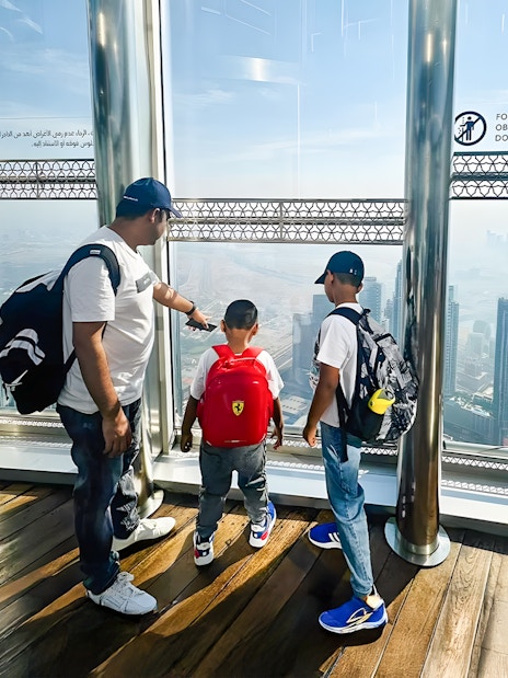 Family enjoying the view from The View At The Palm, overlooking Dubai skyline.