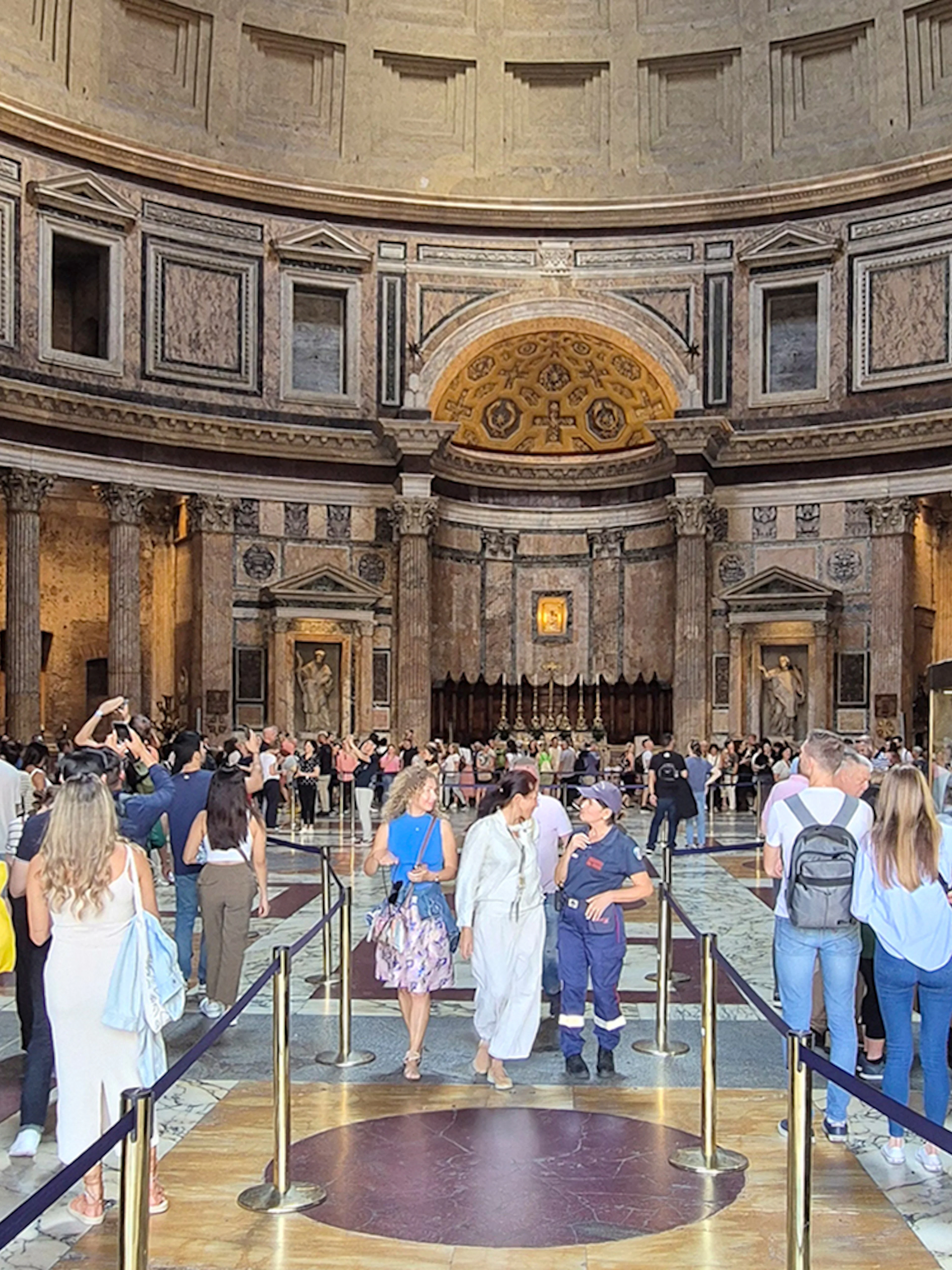 Tourists exploring the interior of the Rome Pantheon, an ancient Roman temple.