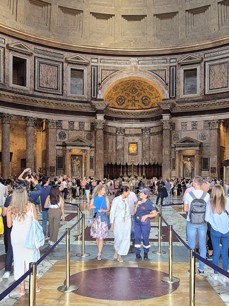 Tourists exploring the interior of the Rome Pantheon, an ancient Roman temple.
