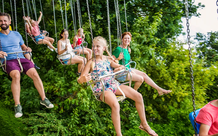 Tourists enjoying flying carousel ride at Bellewaerde Park, Belgium.