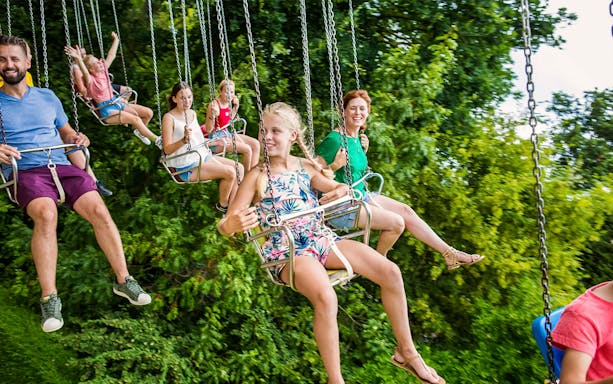 Tourists enjoying flying carousel ride at Bellewaerde Park, Belgium.