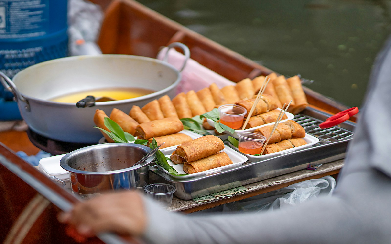 Boat vendor selling food at Damnoen Saduak Floating Market, Bangkok.