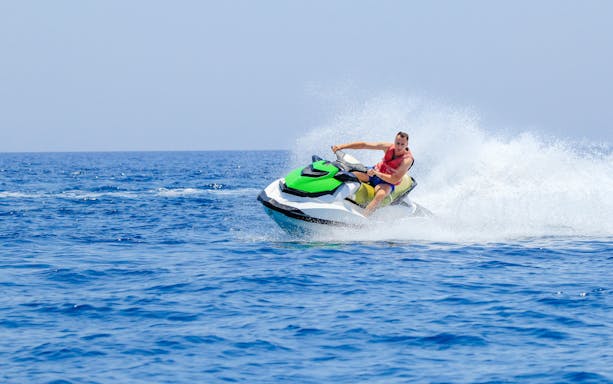 Man riding jet ski on open water in Dubai.