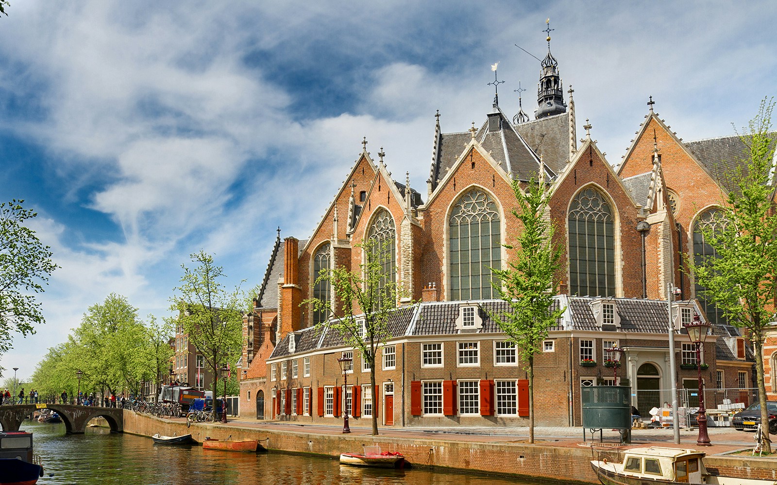 Oude Kerk in Amsterdam with canal and bridge in foreground.