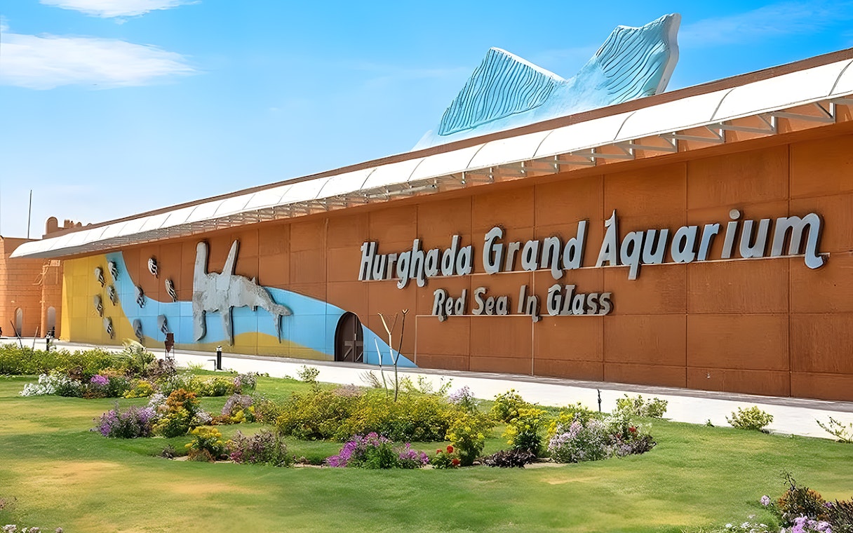 Hurghada Grand Aquarium entrance with colorful mural and garden.