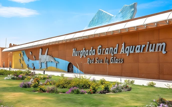 Hurghada Grand Aquarium entrance with colorful mural and garden.