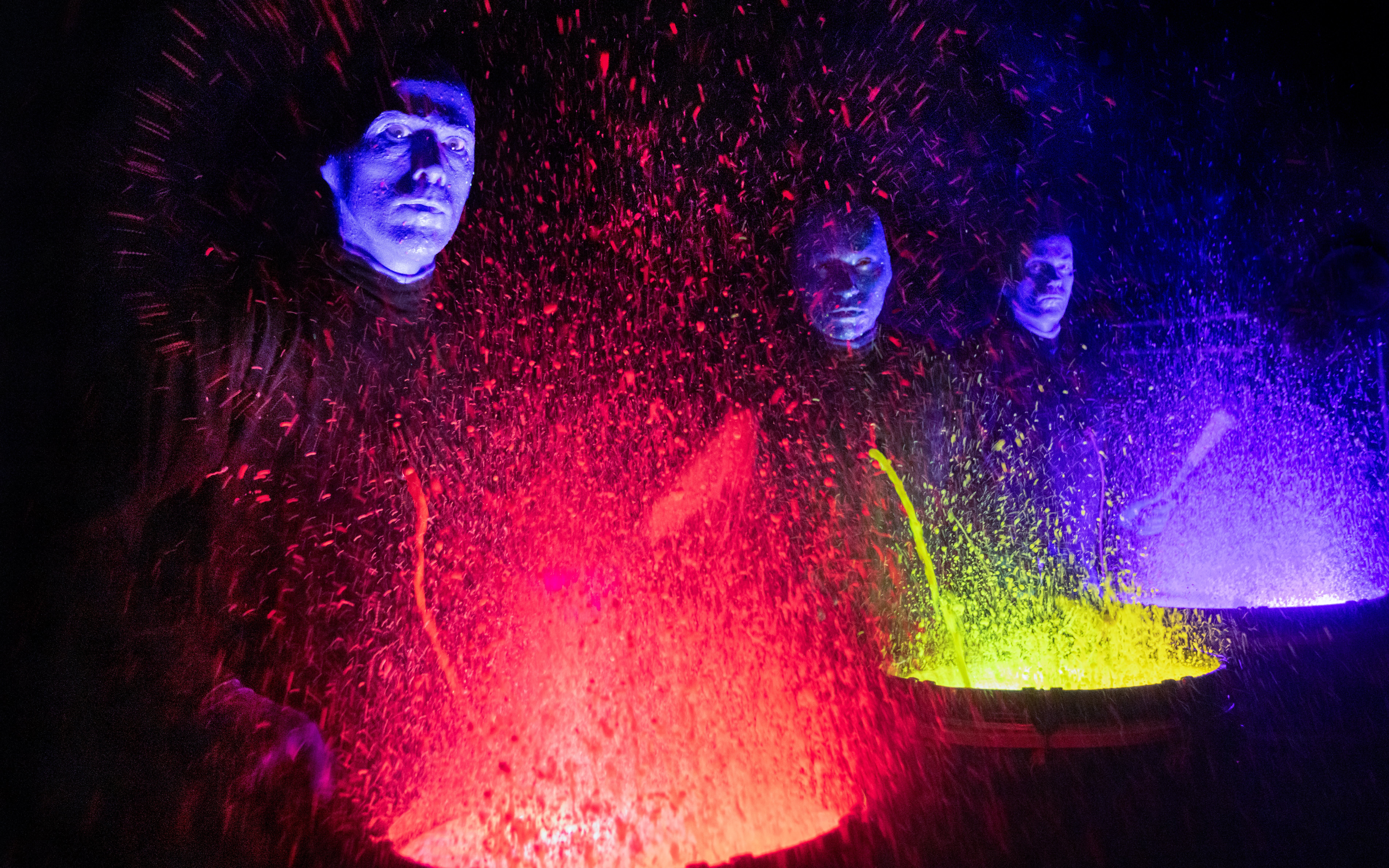 Blue Man Group performing with colorful paint drums in Orlando.