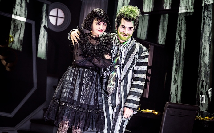 Stage performance of Beetlejuice in West End with two actors in costume.