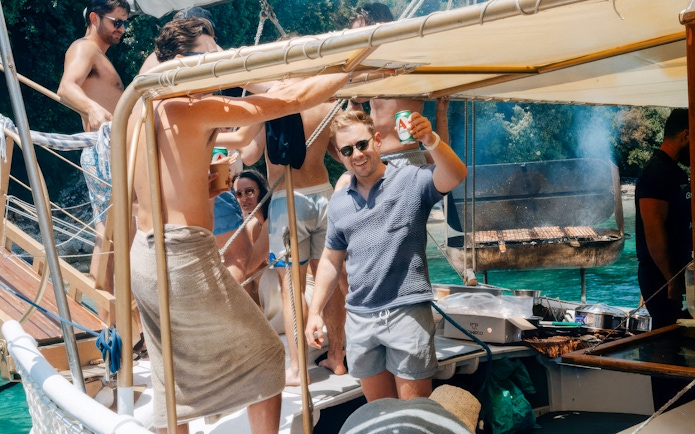 People enjoying a barbecue on a boat during a full-day cruise in Corfu.