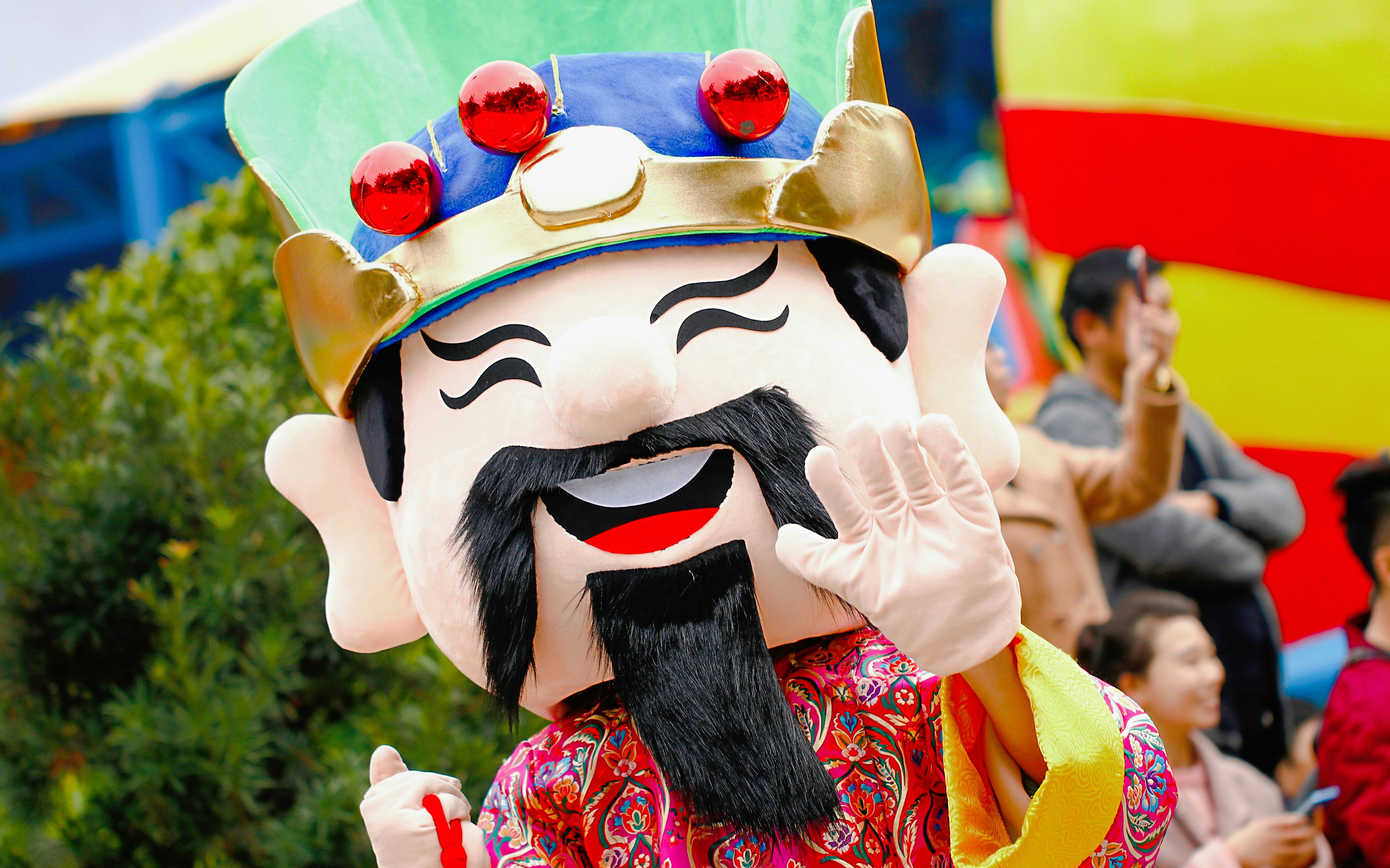 Mascot waving during parade at amusement park.
