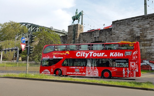 Hop on Hop off City Tour bus in front of Hohenzollern Bridge, Cologne.