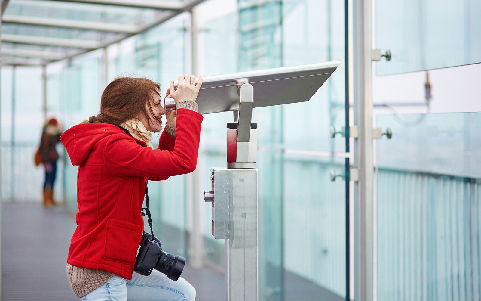 Visitor using telescope on Montparnasse Tower 56th Floor terrace, Paris.