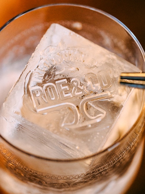 Roe & Co Distillery logo on ice cube in a glass.