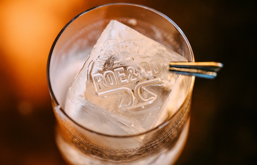 Roe & Co Distillery logo on ice cube in a glass.