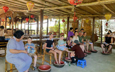 Visitors enjoying foot baths and massages at a craft village on the Hoi An bicycle tour.