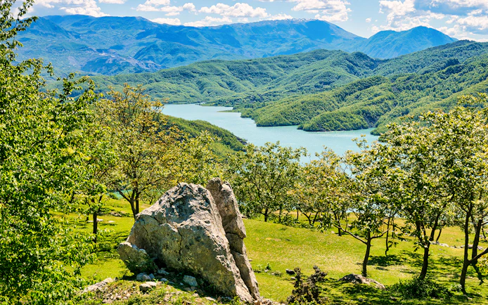 Bovilla Lake view with surrounding green hills during Bovilla Lake & Gamti Mountain Hiking tour.