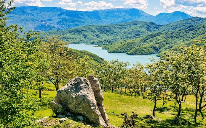 Bovilla Lake view with surrounding green hills during Bovilla Lake & Gamti Mountain Hiking tour.