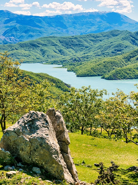 Bovilla Lake view with surrounding green hills during Bovilla Lake & Gamti Mountain Hiking tour.