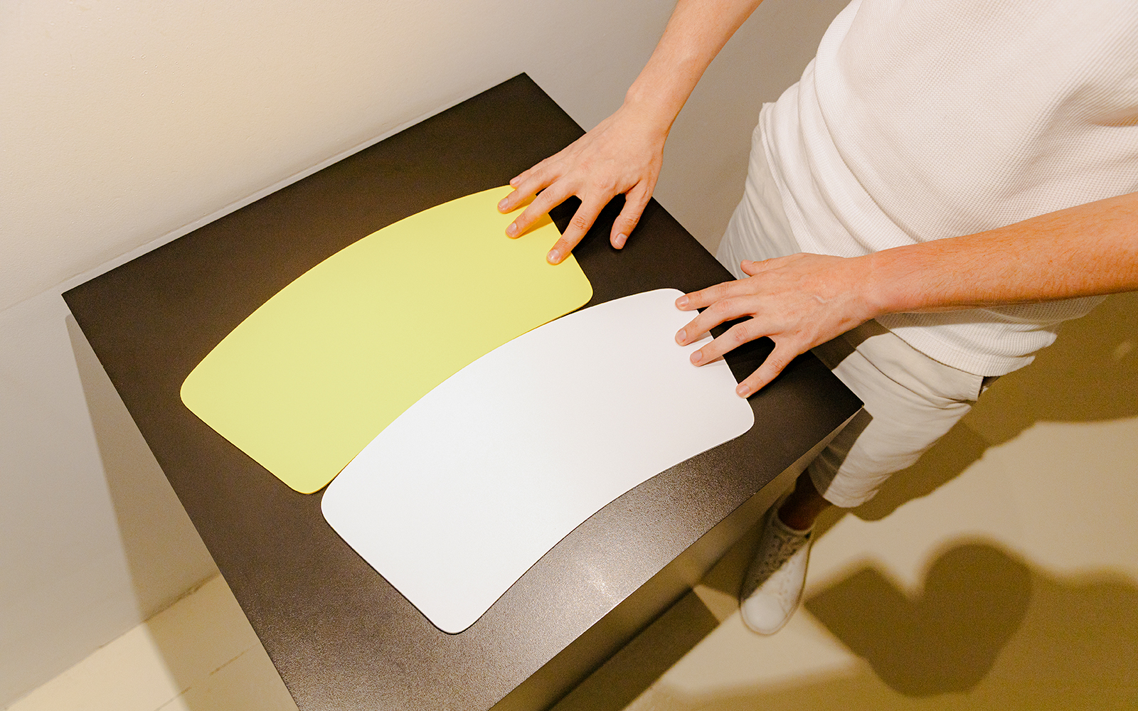Hands interacting with color-changing panels at the Museum of Illusion installation.