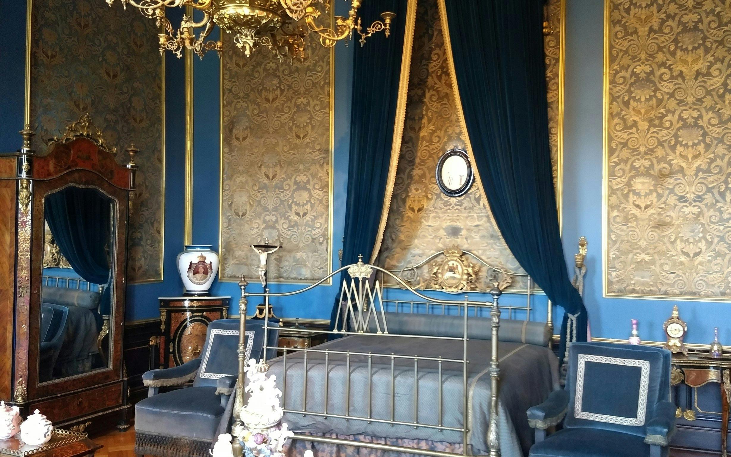 Chapultepec Castle bedroom with ornate bed, antique furniture, and decorative wallpaper.