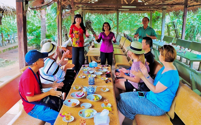 Tourists enjoying a traditional music performance during a Mekong Delta full day tour.