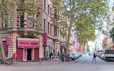 Street view of St. Pauli with shops and pedestrians, part of a guided culinary food tour.