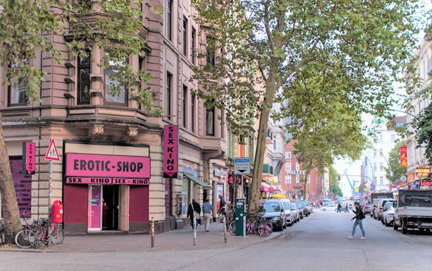 Street view of St. Pauli with shops and pedestrians, part of a guided culinary food tour.