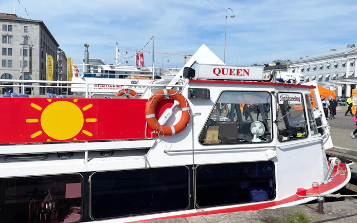 Ship docked at Market Square, Cholera Pool, Finland, with sightseeing signage.