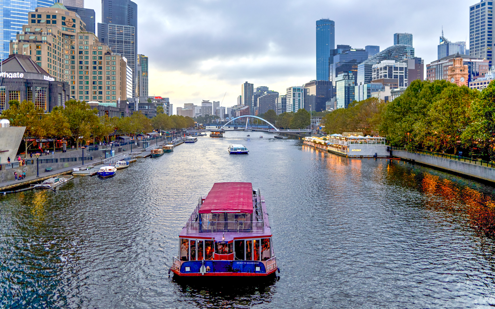 Dinner cruise boat on Yarra River with Melbourne skyline in the background.