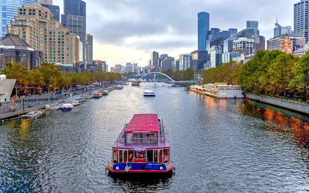 Dinner cruise boat on Yarra River with Melbourne skyline in the background.