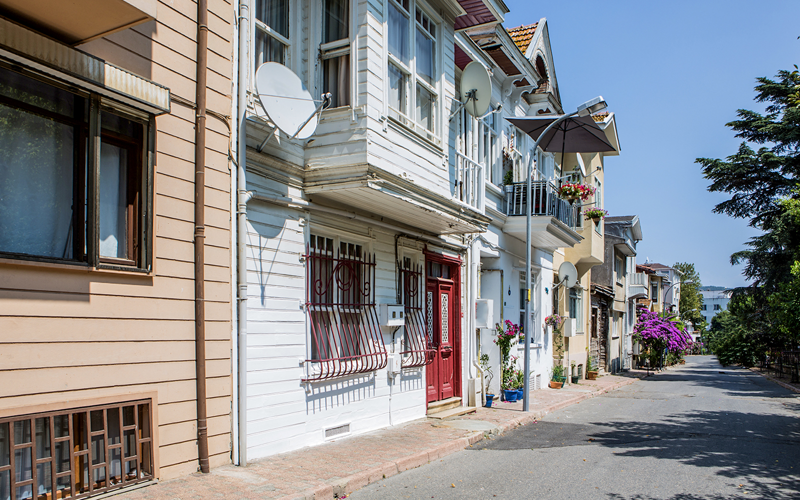 Streetscape of Princess Island with traditional houses and blooming flowers.